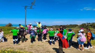 Profesor explicando a unos niños temas de aves dentro de las actividades de Chiclana Natural.