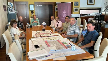 Mesa de reuniones de Chiclana con los miembros de "Hablando Claro" y el alcalde José María Román, presidiendo.