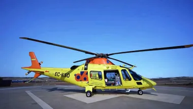 Helicóptero amarillo del 112 del servicio de emergencia en la pista de aterrizaje.
