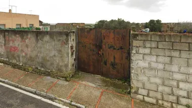 Muro de cemento y puerta de acero oxidada donde se hará la zona verde en San Fernando.
