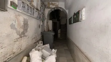 Entrada de la finca número 19 de la calle Javier de Burgos de Cádiz, con enseres y escombros abandonados