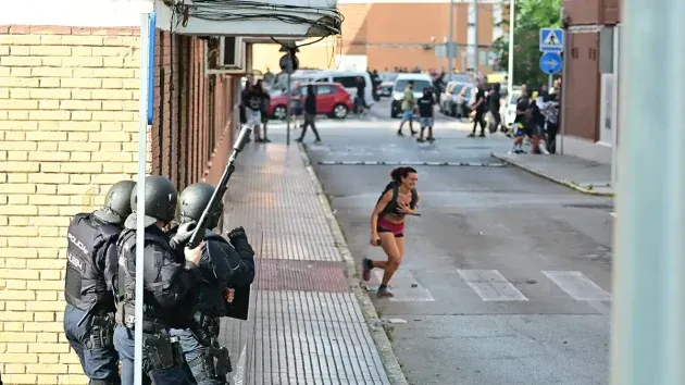 Una joven sale corriendo en un momento de tregua en los enfrentamientos entre antidisturbios y manifestantes en lso que quedó atrapada.