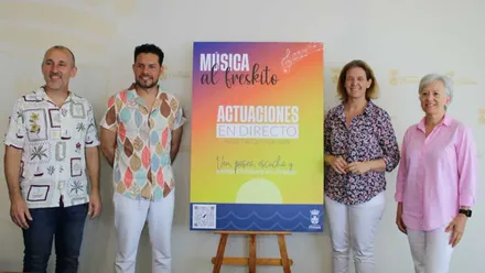 La delegada junto con organizadores y cantantes de "Música al fresquito", todos lucen ropa veraniega.