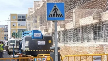 Fachada de un colegio de San Fernando con protección de redes por las obras.