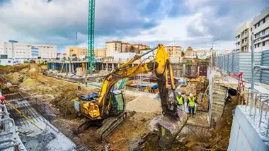 Maquinaria de obras, en amarillo, en una edificación en San Fernando trabajando en la tierra.