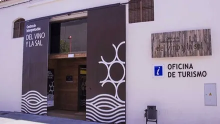 Oficina de Turismo de Chiclana con la fachada en blanco y las puertas en color marrón.