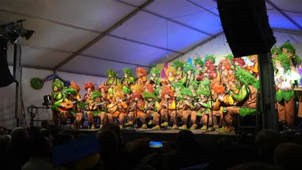 Coro Ley Natura con atuendo con motivos florales y de arbustos.