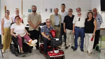 José María Román con chaqueta beige y los miembros, en carrito eléctrico, de La Rampa.