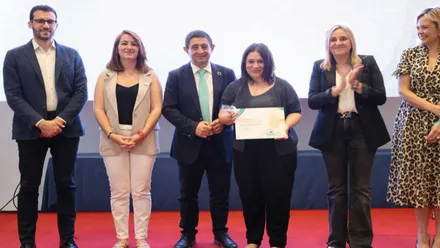 Susa Rivas sostiene el título como reconocimiento al papel solidario de Chiclana, posa junto a otros miembros de la FAMSI.