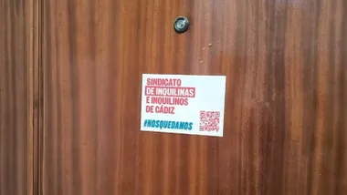 Pegatina del Sindicato de Inquilinas e Inquilinos en una de las puertas de la finca de Javier de Burgos 19 de Cádiz. Foto: José Luis Porquicho Prada.