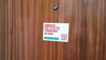 Pegatina del Sindicato de Inquilinas e Inquilinos en una de las puertas de la finca de Javier de Burgos 19 de Cádiz. Foto: José Luis Porquicho Prada.