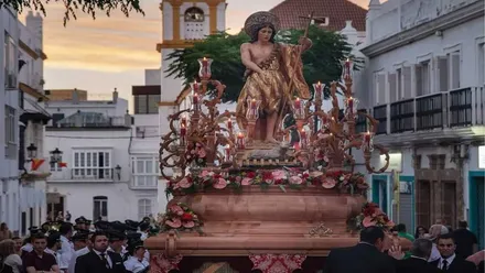 Paso de San Juan Bautista por las calles de Chiclana con la torre al fondo.