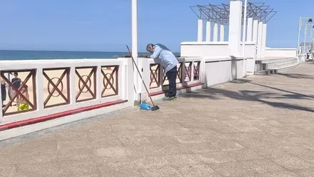 Un operario pinta un tramo de balaustrada de la Playa Victoria
