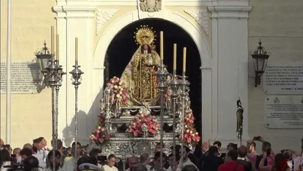 La Virgen del Carmen, en un día soleado, saliendo por la puerta de su convento.