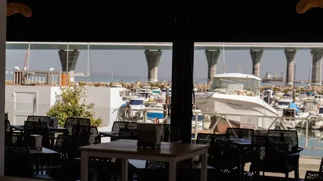 Vista de la terraza exterior al atardecer, con las embarcaciones del puerto al fondo.