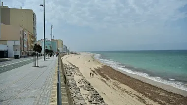 Comienzo de la Playa de la Victoria, con algas en la orilla
