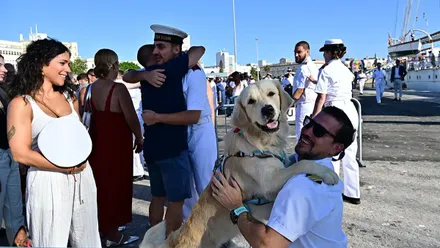 Un guardiamarina recibe un abrazo perruno