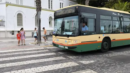Un autobús de servicios mínimos deja pasar a unos peatones.