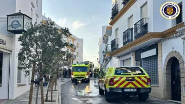 Camión y coche de bomberos en la calle del incendio en Conil.