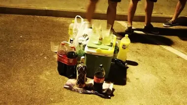 Botellas de alcohol y refrescos en el suelo para hacer un "botellón".