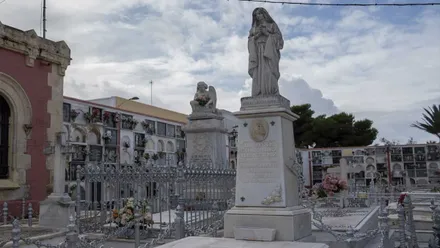 Imagen de una Virgen de piedra en una tumba del cementerio de San Fernando, en Cádiz.