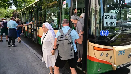 Integrante del comité ayudando a bajar a dos monjas del autobús