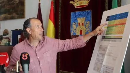 José María Román, con camisa rosa, explica sobre un display el crecimiento de la población de Chiclana.