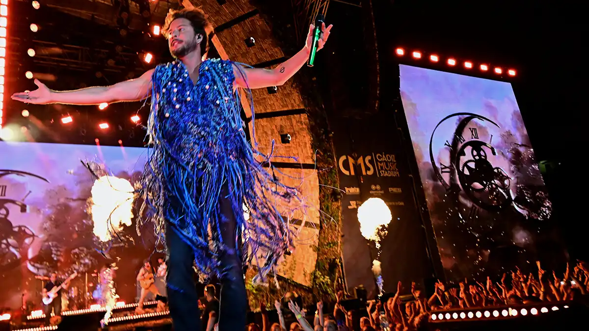 Manolo Carrasco en el escanrio con parte del público detrás saltando.