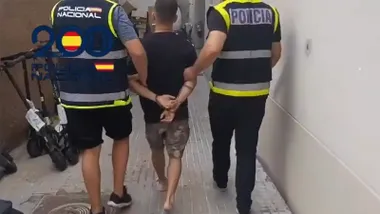 El último detenido pro la Policía Nacional por los disturbios por la huelga del metal entra en las dependencias policiales esposado junto a dos agentes.