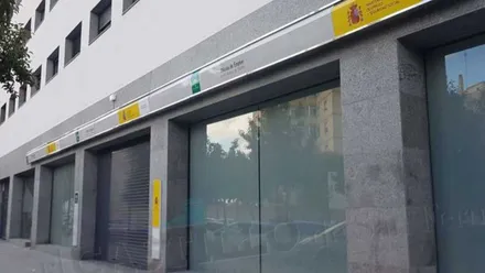 Oficina de desempleo de la Junta de Andalucía, cristalera y asfalto con predominio del gris, en San Fernando.