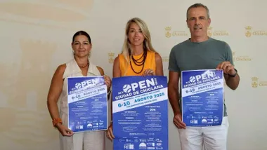 Isabel Butrón en el centro de la imagen, con camisa naranja, sosteniendo el cartel y acompañada de los organizadores.