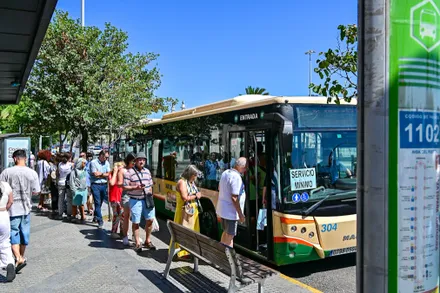 Personas usuarias del servicio de transporte suben a un autobús de los servicios mínimos durante la huelga