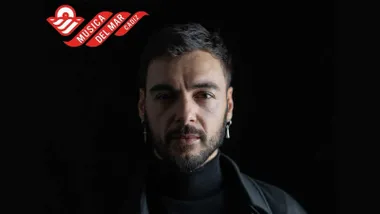 El cantante RAULE con fondo negro, él luce indumentaria negra, arriba el sello rojo de "Música del Mar" en Cádiz.