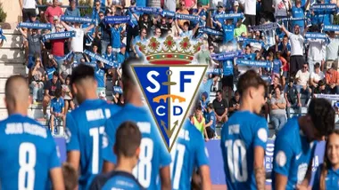 Jugadores y grada del San Fernando CD con camisetas azules, predomina el escudo en primer término.
