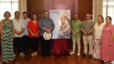 Representantes del Ayuntamiento y organización junto al cartel de la fiesta de Santa Ana.