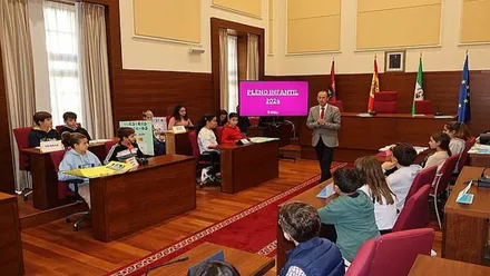 José María Román, con chaqueta, en el pleno infantil del Ayuntamiento de Chiclana.