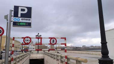 Vista de una de las entradas al aparcamiento del Campo del Sur, en Cádiz. Se observan señales de deterioro en la estructura y ausencia de actividad de obras. Al fondo se distingue el Paseo del Campo del Sur y la Catedral de Cádiz.