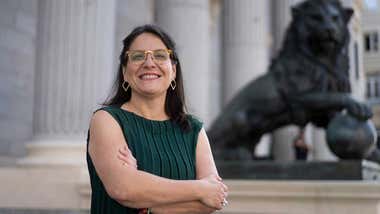 La diputada por Cádiz Esther Gil de Reboleño posa ante la entrada principal del Congreso de los Diputados, con uno de los leones de bronce y las columnas del Palacio de las Cortes al fondo.