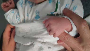 La mano de un recién nacido (o una) con las manos del padre o la madre.