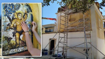 Manos rehabilitando un retablo religioso y el edificio de la Caja del Agua en segundo plano.