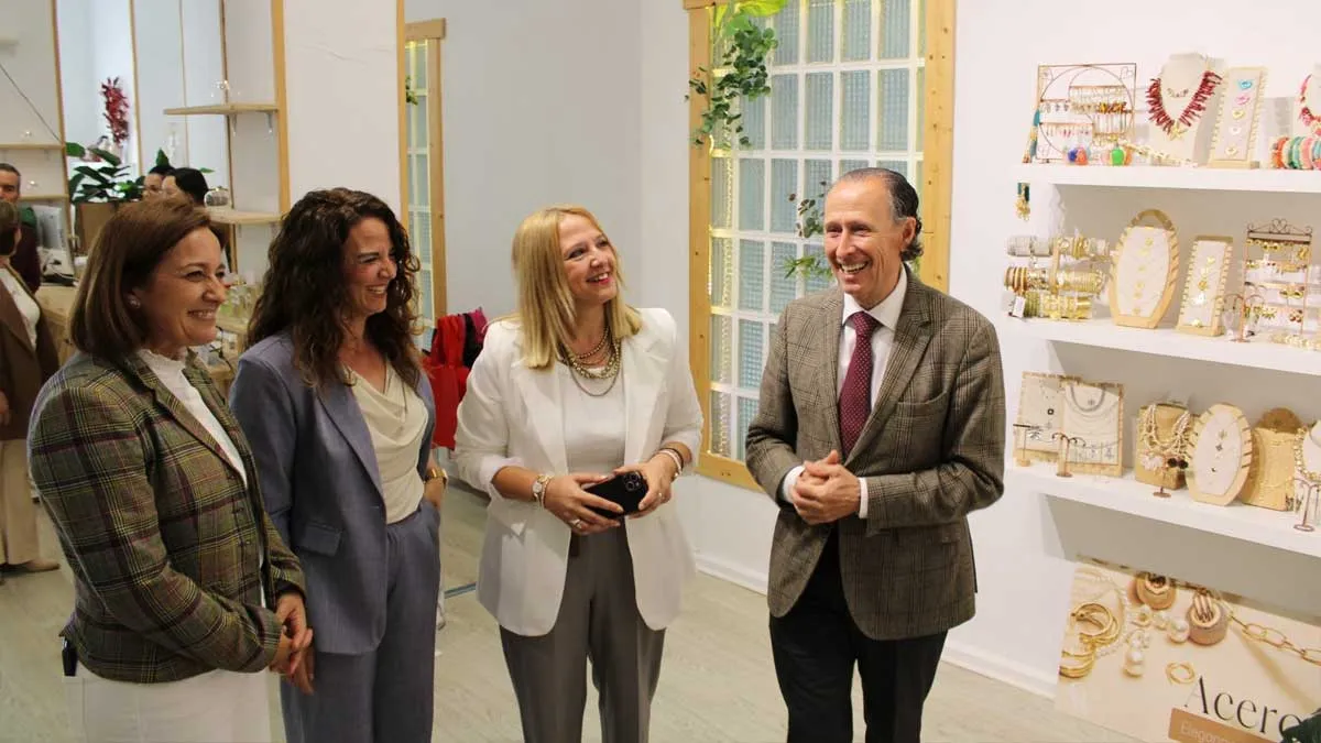 El alcalde José María Román junto a Ana González y Isabel y Carmen Guerrero en el establecimiento nuevo junto a una estantería con productos.