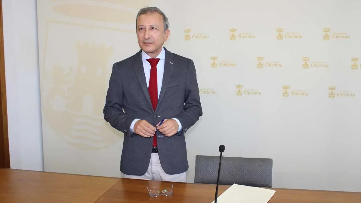 Rodolfo Pérez, delegado de Urbanismo de Chiclana, de chaqueta con el fondo blanco y escudos dorados de la ciudad.