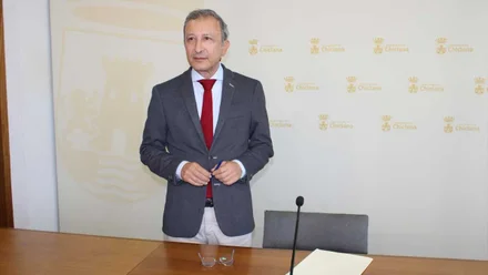 Rodolfo Pérez, delegado de Urbanismo de Chiclana, de chaqueta con el fondo blanco y escudos dorados de la ciudad.