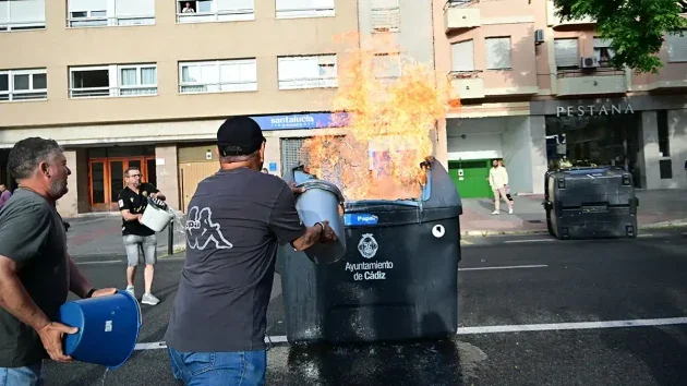 Vecinos apagan un contenedor de basura en llamas