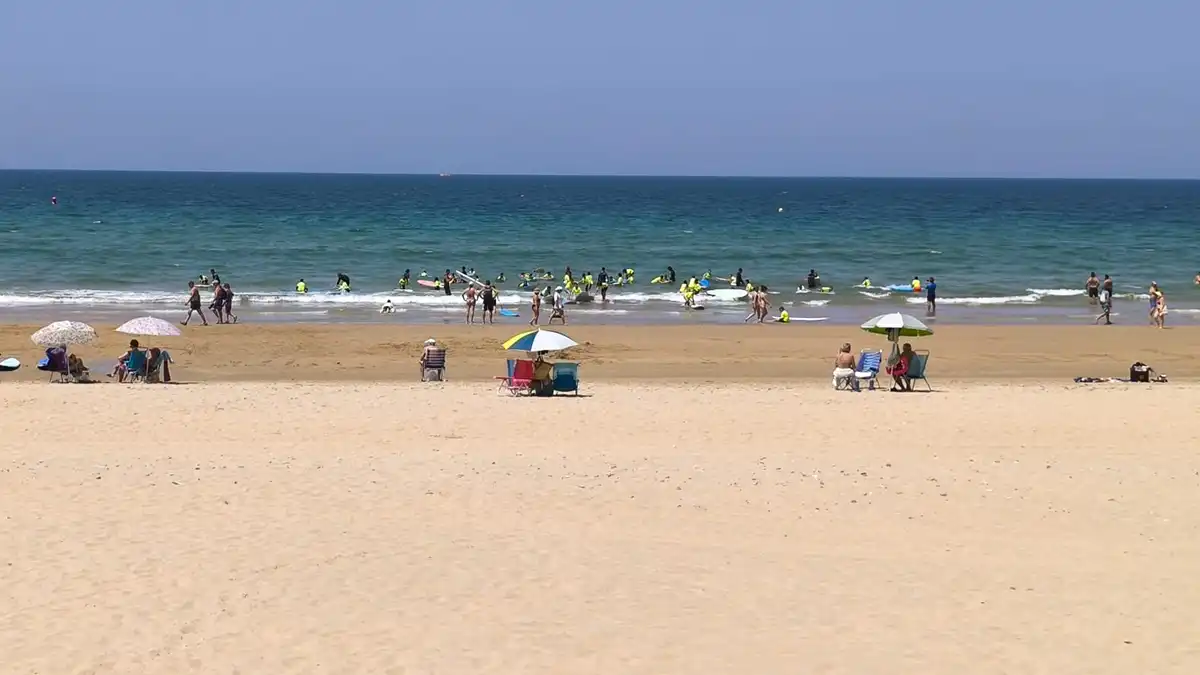 Un grupo de jóvenes surfistas en la playa de la Victoria de Cádiz