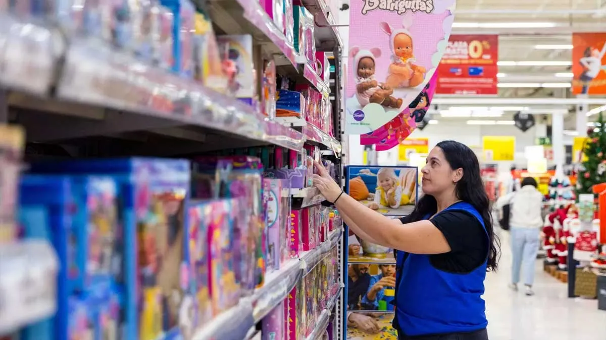 Mujer colocando unos juguetes en una estantería.