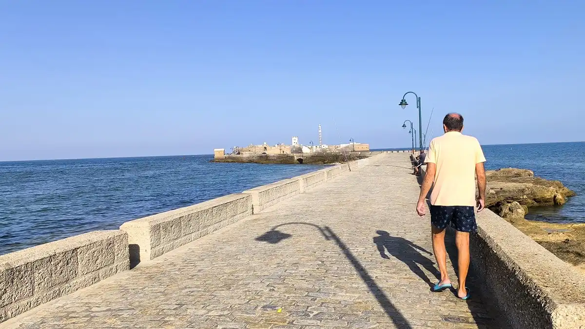 Una bañista por el Paseo Quiñónes con el Castillo de San Sebastián al fondo