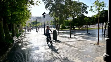 Mujer con bicicleta por la Plaza de España con buen tiempo