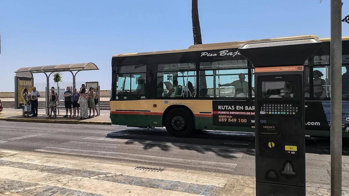Un autobús urbano de Cádiz entra en una parada del Campo del Sur repleta de personas