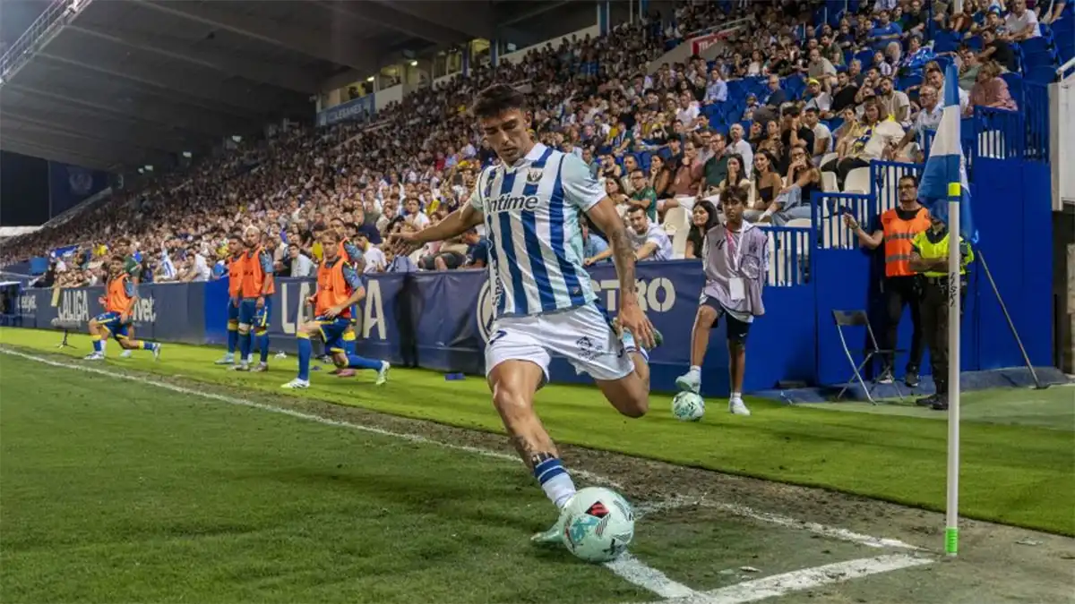 Imagen de un saque de esquina con varios jugadores en el área y el balón claramente teñido de verde brillante